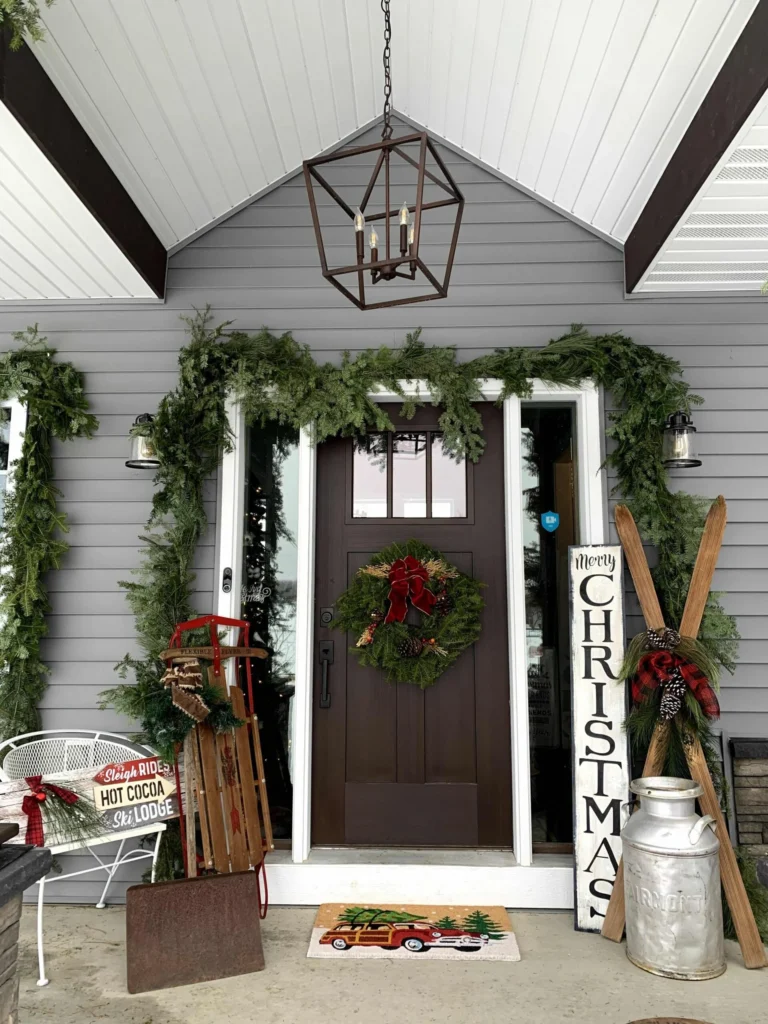 Front porch decorated with garland, a wreath and a Merry Christmas sign by Rustic Bling